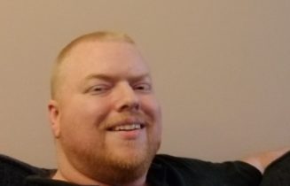 Man sitting on couch in black shirt